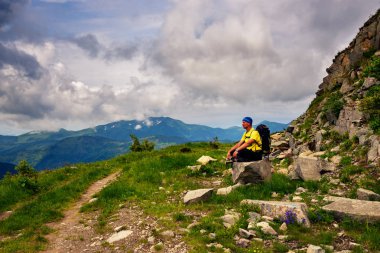 Maceracı büyük taş, ormanlık tepeler Panoraması hayran hangi ufuk düşük ağır bulutlar altında uzanan dağ izi rahatlatıcı oturuyor.