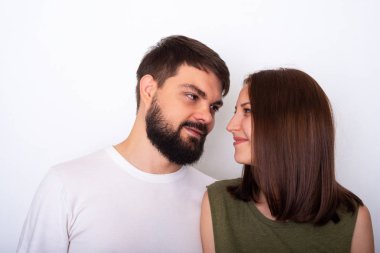 Genç güzel gülümsüyor ve görünüyor her diğer için hafif bir arka plan üzerinde çift