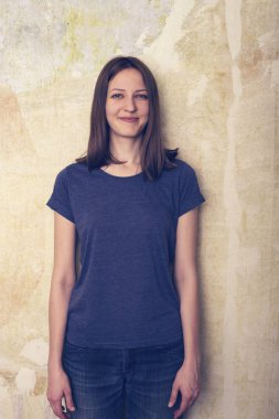 Genç kız kameraya doğru grunge arka plan üzerinde görünüyor. 