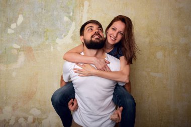 Mutlu güzel genç çift bir grunge duvar arka plan üzerinde eğleniyor