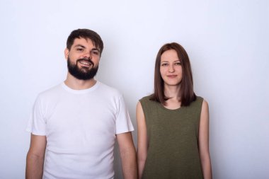 Rahat kıyafetler içinde genç çift kamera studio ve gülümseyerek bakar