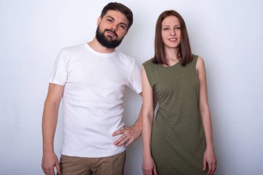 Rahat kıyafetler içinde hoş genç çift kamera studio ve gülümseyerek bakar