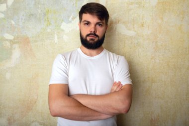 Sakallı genç adam pozlar Studio grunge duvar arka plan üzerinde