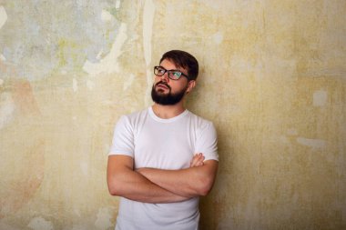 Gözlük teşkil Studio grunge duvar arka plan üzerinde genç adam sakallı