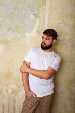 Sakallı genç adam pozlar Studio grunge duvar arka plan üzerinde