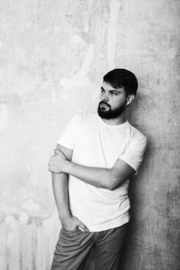 Sakallı genç adam Studio grunge duvar zemin teşkil etmektedir. Siyah ve beyaz stüdyoda vurdu