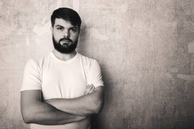 Sakallı genç adam Studio grunge duvar zemin teşkil etmektedir. Siyah ve beyaz stüdyoda vurdu