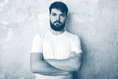 Sakallı genç adam Studio grunge duvar zemin teşkil etmektedir. Siyah ve beyaz stüdyoda vurdu