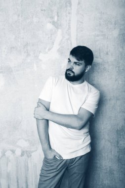 Sakallı genç adam Studio grunge duvar zemin teşkil etmektedir. Siyah ve beyaz stüdyoda vurdu