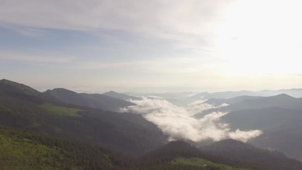 暴风雨后 在高山上的日落上空 云层漂浮在绿色山脉的山脊上 照亮了夕阳照耀下的地平线 — 图库视频影像