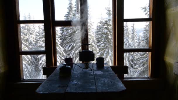 小水壶站在一个煤气燃烧器旁边的钢杯对一个窗口在寒冷的模式 可怕的早晨在一个老山的庇护所在冬季冒险 — 图库视频影像
