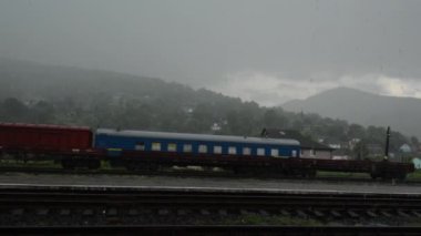 Eski Tren havy yağmur altında bir kırsal demiryolu istasyonu üzerinde duruyor. Kimse bir istasyonda değil