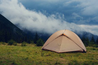 Yeşil dağ çayır düşük ağır bulutlar - fırtına öncesi dağlarda arka plan üzerinde çadır. Geniş açı.