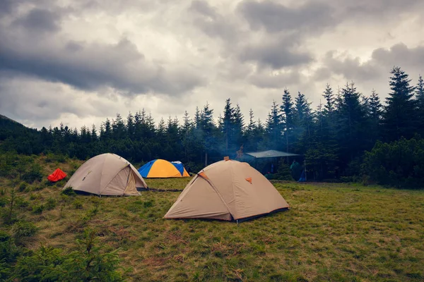 Çadır düşük ağır bulutlar - fırtına öncesi dağlarda zemin üzerine yeşil dağ çayır üzerinde. Geniş açı.