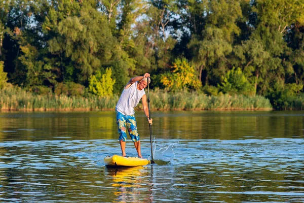 強い男は 大きな川と人生を楽しむ Sup ボードのトレーニングです スタンド アップ パドルボーディング 素晴らしいアクティブな野外レクリエーション — ストック写真