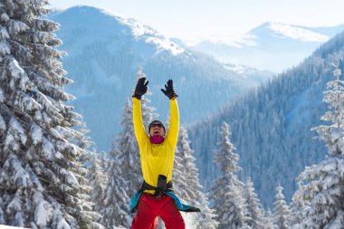 Kollarını açarak maceracı Zıplama, kış dağlarda ile güzel bir güneşli sabah memnun. Epik kış seyahat dağlarda. 