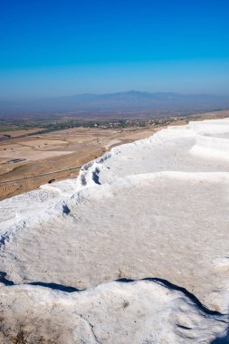Turkuaz termal su havuzlarında yükselen güneş - Pamukkale, Türkiye Turizm landmark ışınları ile beyaz teraslar. Geniş açı, dikey görüntü.
