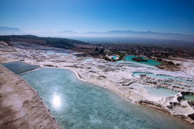 Turkuaz termal su havuzlarında yükselen güneş - Pamukkale, Türkiye Turizm landmark ışınları ile beyaz teraslar. Geniş açı.