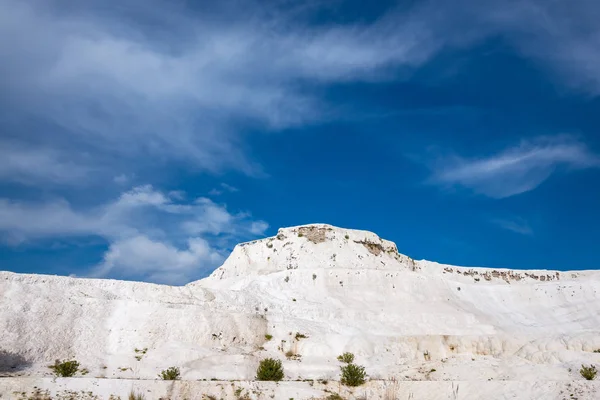 Kar-beyaz tepe üzerinde arka plan mavi gökyüzünde - Pamukkale, Türkiye'de bir turist dönüm noktası. Güneşli bir gün, geniş açı.