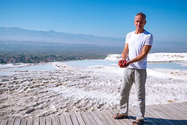 幸せな旅行者に立っている真っ白な丘 パムッカレ トルコ観光名所の背景に彼の手で熟したザクロと — ストック写真