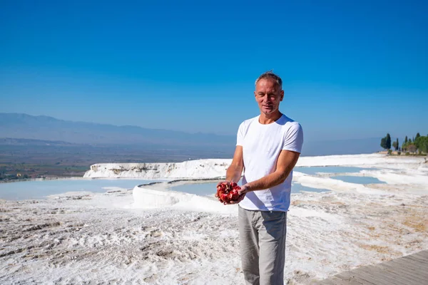 幸せな旅行者に立っている真っ白な丘 パムッカレ トルコ観光名所の背景に彼の手で熟したザクロと — ストック写真