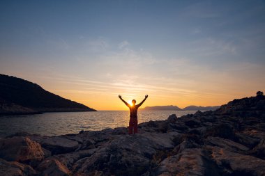 Erkek seyahat zevk yaşam ile muhteşem altın günbatımı güzel bulutlar deniz ile sırasında silah açın. Choban defne, Likya yolu, Mugla, Turkey