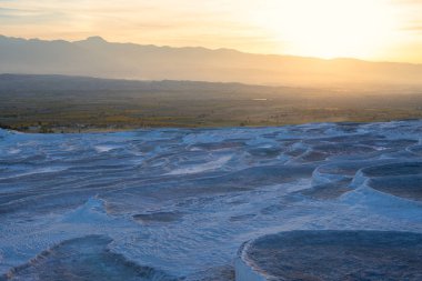 Turkuaz termal su havuzları kırsal günbatımı - Pamukkale, Türkiye Turizm Simgesel Yapı sırasında arka plan üzerinde beyaz Terası. Geniş açı.