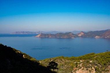 Panoramik manzaralı kayalık kıyıları Akdeniz - Ölüdeniz, Türkiye'de bir turist dönüm noktası turkuaz suları ile çevrili yemyeşil çam ağaçları ile kaplı. Geniş açı.