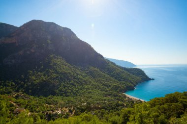 Panoramik manzaralı kayalık kıyıları Akdeniz - Kabak, Türkiye'de bir turist dönüm noktası turkuaz suları ile çevrili yemyeşil çam ağaçları ile kaplı. Geniş açı, arkadan.