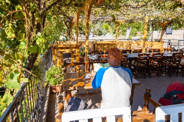 Traveler Sits Terrace Small Cafe Drinks Tea Relaxes Looks Map — Stock Photo, Image