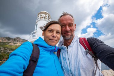 Mutlu çift alarak selfie arka planda deniz feneri, Kaş şehir, Türkiye'de fırtına - Likya yolu gezisi öncesi.