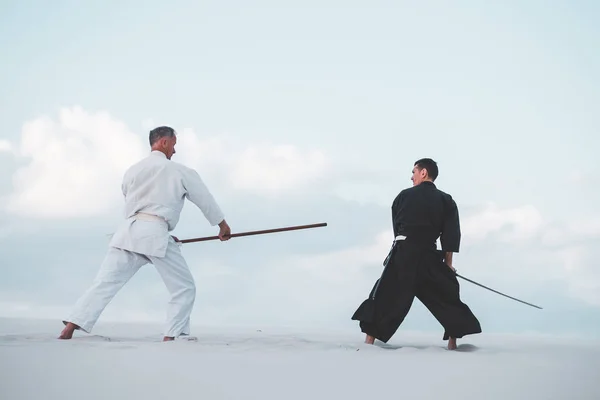 Dos Hombres Vestidos Con Ropa Japonesa Practican Artes Marciales Con Imágenes de stock libres de derechos