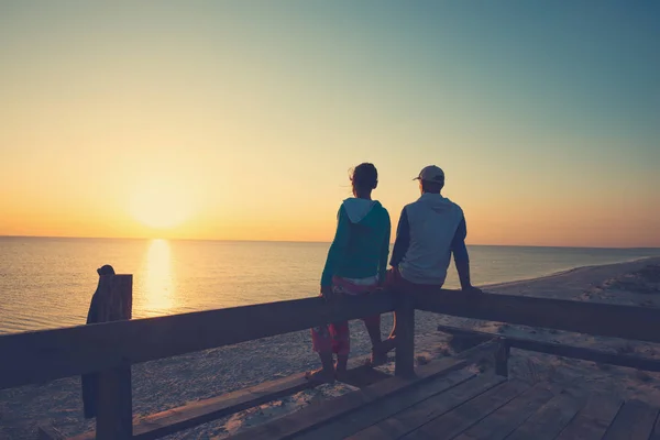 Gelukkige Paar Ontspant Veranda Van Een Bungalow Zonsondergang Zee Bewonderen Stockafbeelding