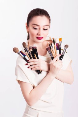 Beyaz backgrou üzerinde güzel bir kız ve makyaj fırça yüz