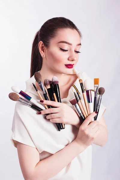 Het gezicht van een mooi meisje en make-up borstel op witte CHTERGRO — Stockfoto