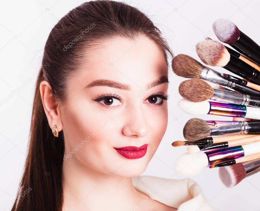 The face of a beautiful girl and make-up brush on white backgrou