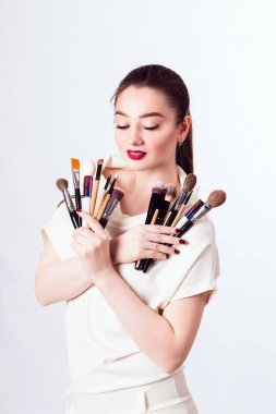 Beyaz arka planda elinde fırçayla makyaj sanatçısı.