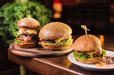 Siyah arka planda baharatlı lezzetli bir burger.