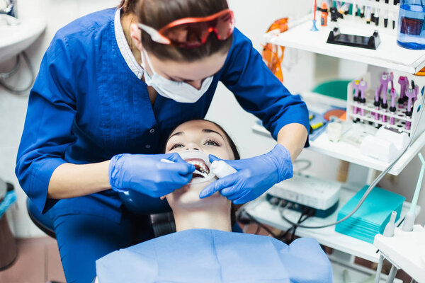 Процедура отбеливания зубов стоматологом
