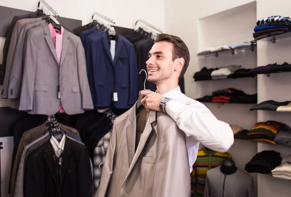 The man buyer chooses jacket the boutique