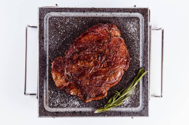 ızgara et biftek sıcak granit plaka üzerinde beyaz bir arka plan (en iyi Görünümü Kapat)