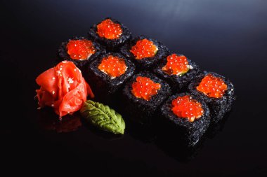 Suşi ile Somon havyar siyah bir arka plan üzerine alır. Geleneksel Japon mutfağı