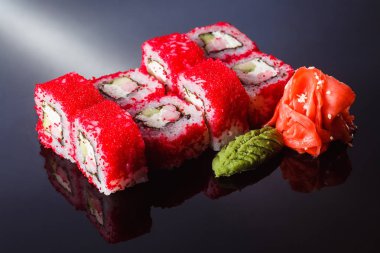 Suşi California karides ile siyah bir arka plan üzerine alır. Geleneksel Japon mutfağı