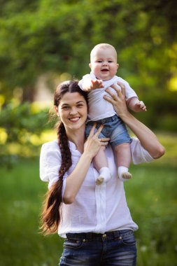 Anne doğanın ellerinde küçük bir oğul tutuyor. Çocukla yürü..