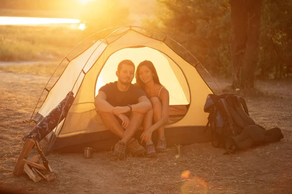 Een man en een vrouw zitten in een tent bij zonsondergang. Huwelijksreis in — Stockfoto