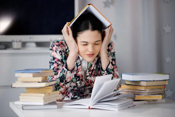 Een jonge vrouw zit voor een stapel papieren en een computer-h — Stockfoto