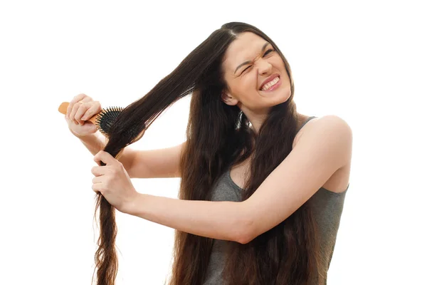 Una mujer joven no puede peinar el cabello enredado problemático. ¿Qué? — Foto de Stock