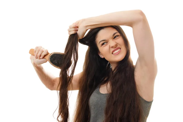 Uma jovem mulher não pode pentear o cabelo emaranhado problemático. Whi... — Fotografia de Stock