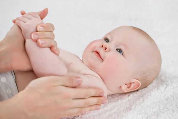 Médico feminino fazendo massagem e bebê ginástica em um backgr leve — Fotografia de Stock