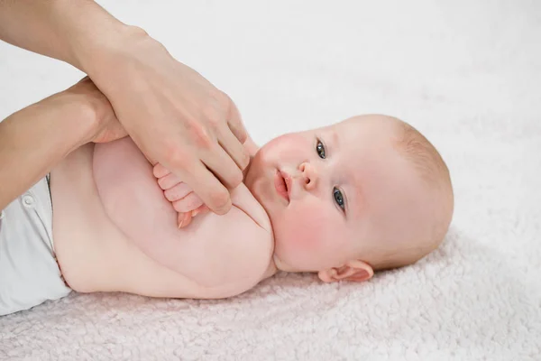 Médico feminino fazendo massagem e bebê ginástica em um backgr leve — Fotografia de Stock